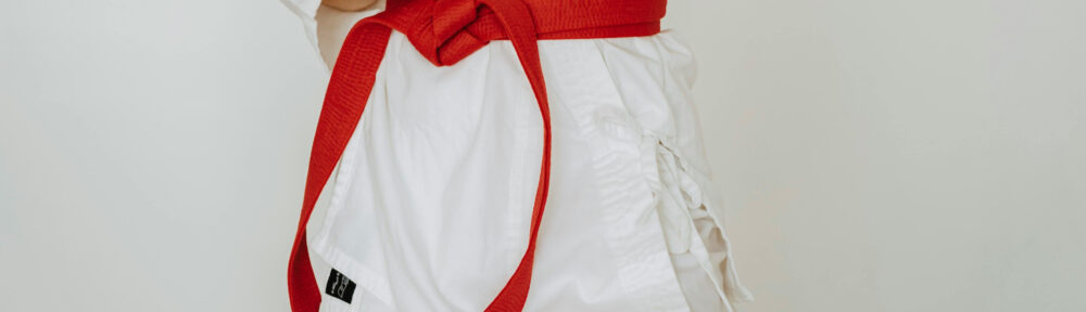 Cropped Photo of a person wearing a white tae kwon do uniform and a red belt